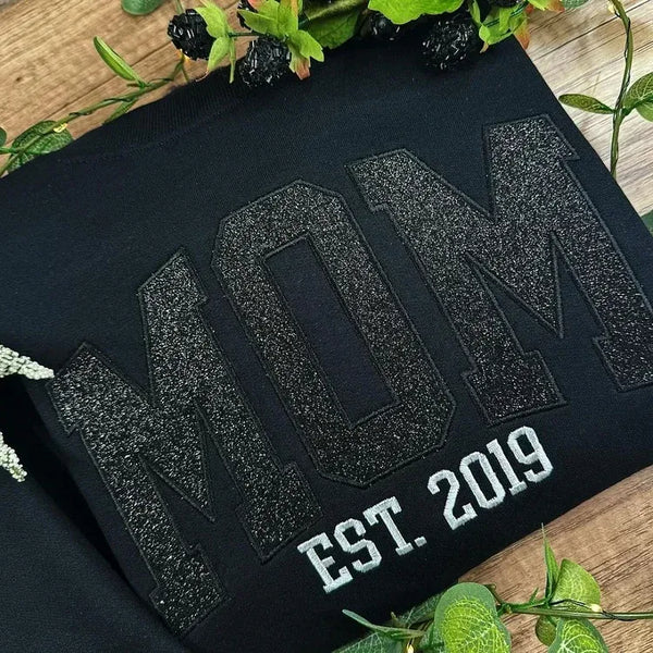 Glitzerndes Mama-Sweatshirt mit gestickter Applikation und Kindernamen auf dem Ärmel